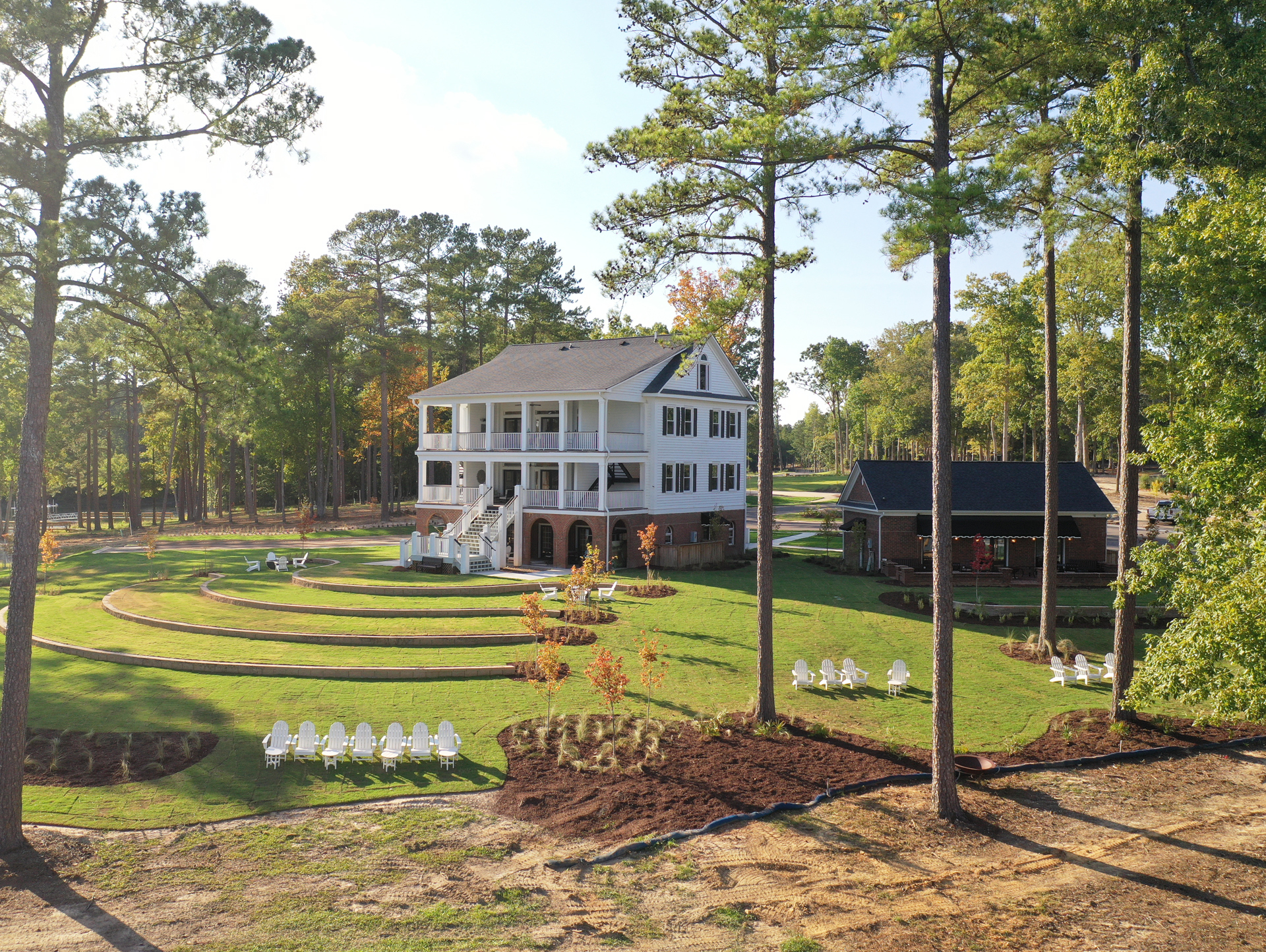 The Historic Clubhouse, Smart Gym & Yoga Lawn Sit Atop The Slope with the Amphitheater Tiered Towards the Lake
