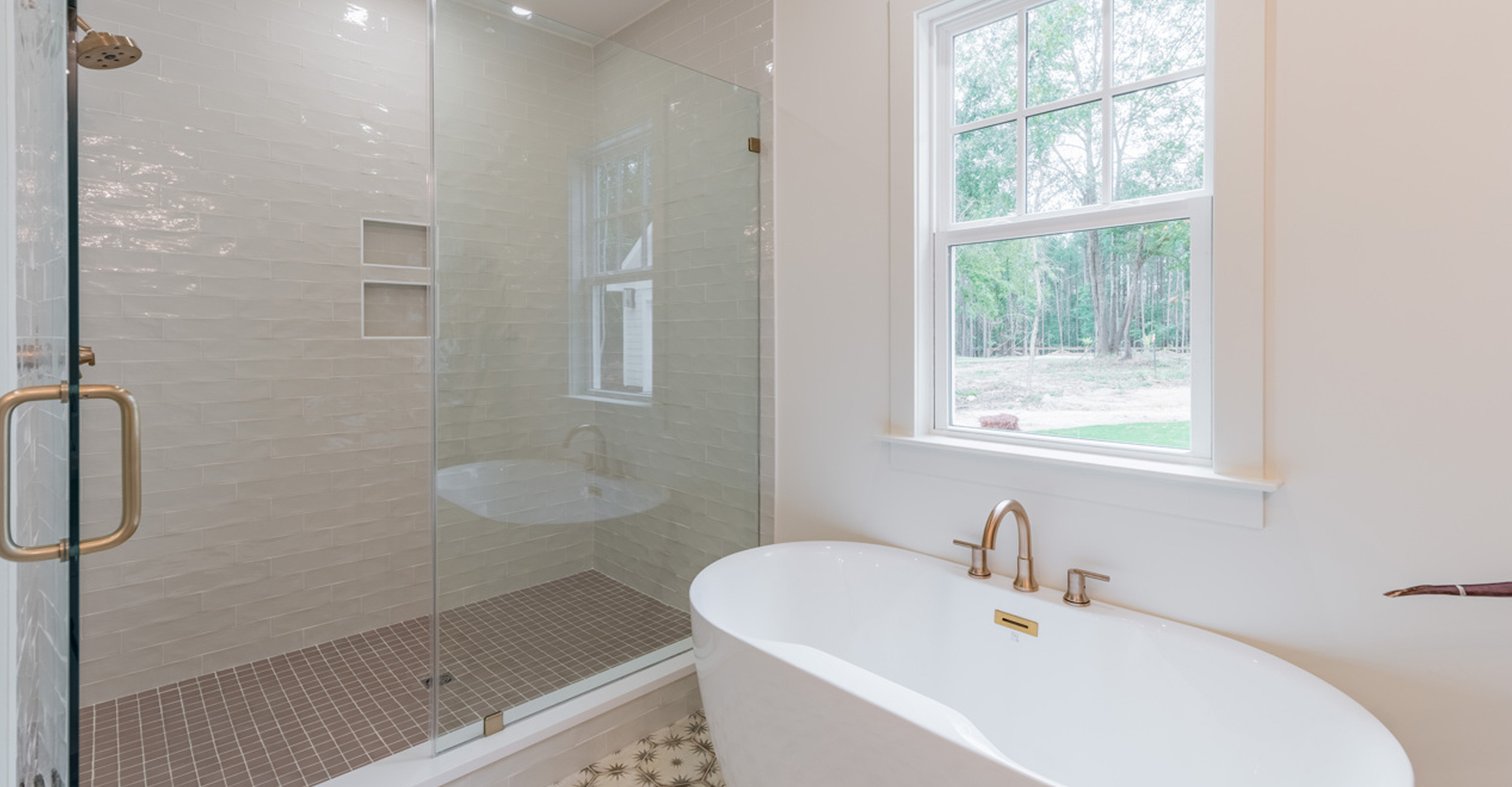 The Herschel by LaFaye Custom Homes Main Level Master Bath with Tile Shower, Freestanding Tub Set under Window, Enclosed Water Closet & Double Vanity